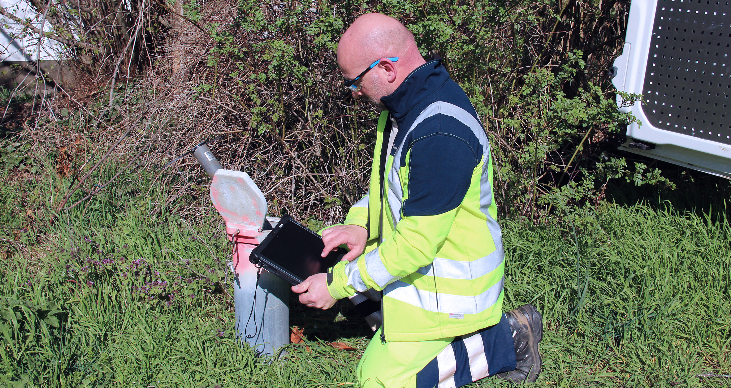 Mann lies Datenlogger einer Grundwassermessstelle aus