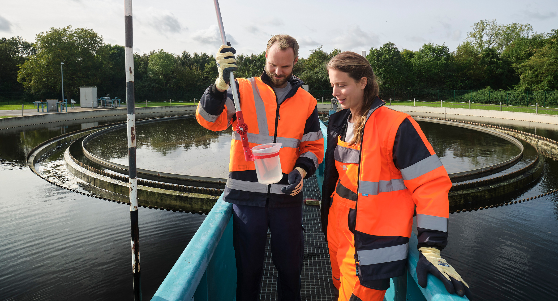 zwei Kolleg*innen schauen sich eine Wasserprobe an