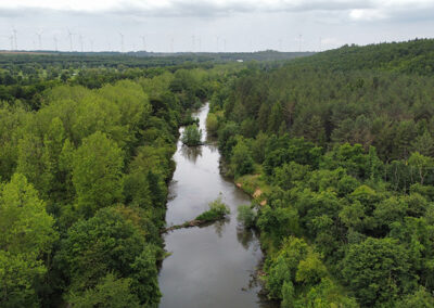 Drohnenaufnahme der Erft in Frimmersdorf mit Blick auf einen Windpark