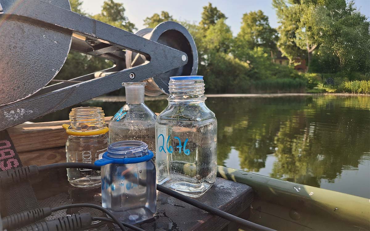 Probengläser stehen auf einem Boot im Fluss