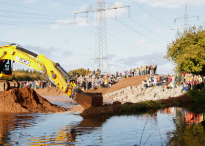 Erfteinweihung – Durchstich startet, das Wasser kann fließen, Zuschauer stehen am Ufer